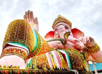 Low angle view of statue against temple building against sky