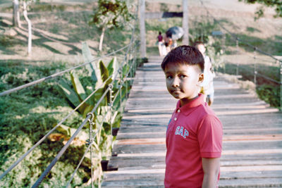 Portrait of boy standing on staircase