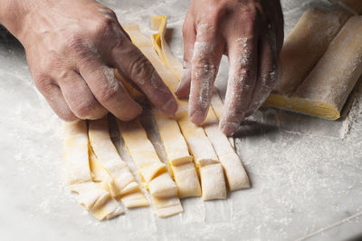Cropped hands of chef preparing dough on table in commercial kitchen