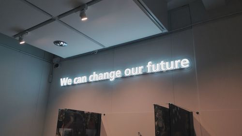 Low angle view of illuminated text on wall at store