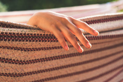 Cropped hand relaxing on hammock