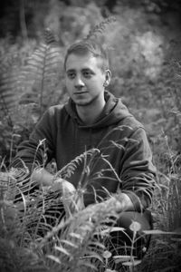 Portrait of young man sitting on field