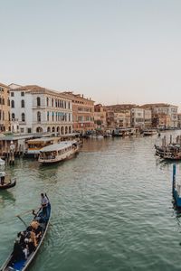 Boats in canal against clear sky