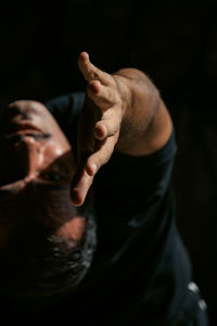 Midsection of yoga man against black background