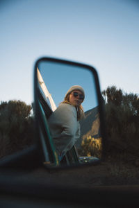 Full length of young woman against blue sky