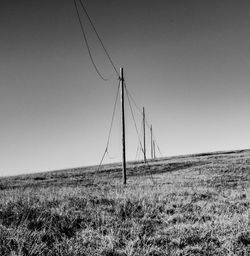 Wind turbines on field against clear sky