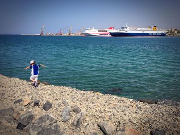 Man standing on sea against clear sky