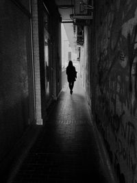 Rear view of silhouette man walking on corridor