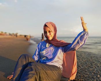 Portrait of young woman sitting on beach