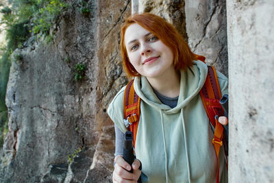 Portrait of woman standing against rock formation