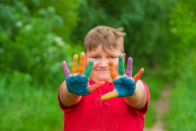 Portrait of boy showing colored palm of hands