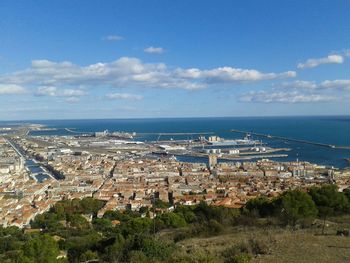 Aerial view of town by sea against sky