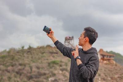 A man taking a selfie at a tourist spot
