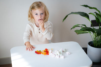 Portrait of young woman sitting on table