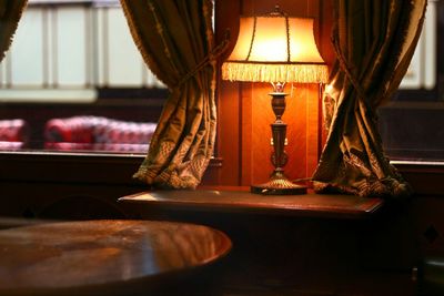 Close-up of illuminated lamp on table at home