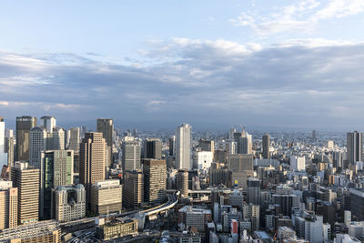 Aerial view of city against cloudy sky