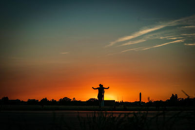 Silhouette statue against sky during sunset
