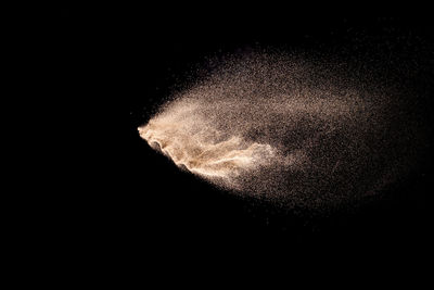 Defocused image of powder paint against black background