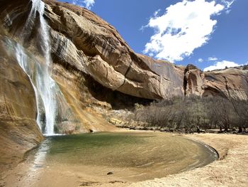 Scenic view of waterfall against sky