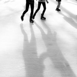 Low section of people ice-skating at rink