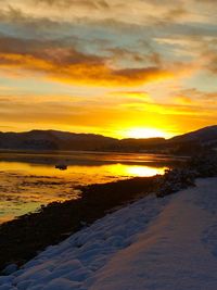 Scenic view of lake against orange sky