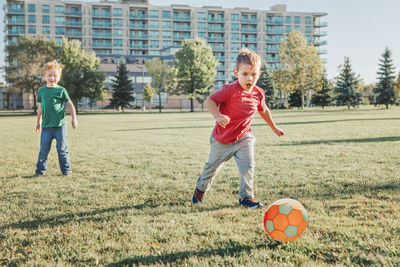 Full length of boy playing with ball at park