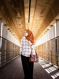 Full length of woman walking on footpath