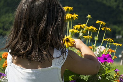 High angle view of girl holding black-eyed susan at park
