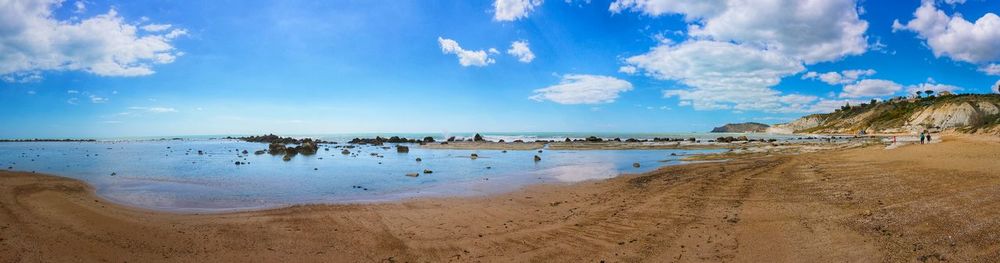 Scenic view of beach against cloudy sky