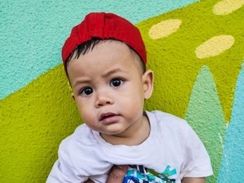 Portrait of cute baby girl against wall