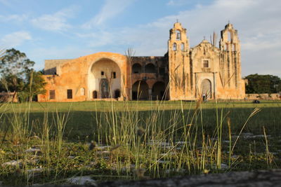 View of historic building by lake against sky