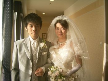 Portrait of smiling bride and groom standing by window