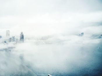 Calm misty river with buildings in distance