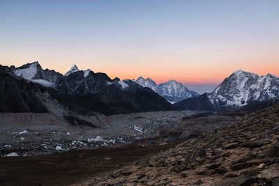 Scenic view of snowcapped mountains against clear sky during sunset