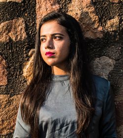 Portrait of beautiful woman standing against wall