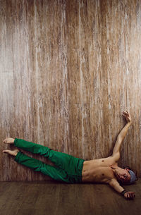 Low section of boy sitting on hardwood floor