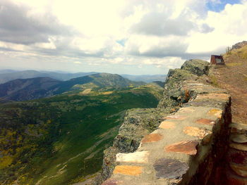 Scenic view of mountains against cloudy sky