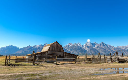 Built structure on field against clear blue sky