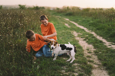 Funny twin brother boys playing outdoors on field at sunset.