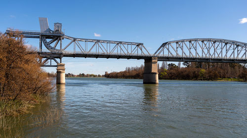 Bridge over river against clear blue sky