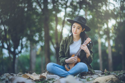 Young woman playing with ball in forest