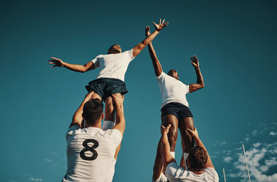 Full length of woman doing yoga against blue sky