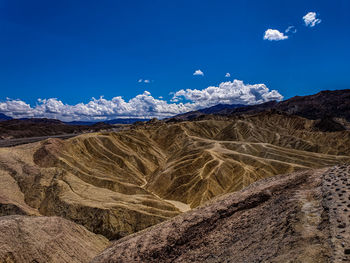 Scenic view of landscape and mountains against blue sky