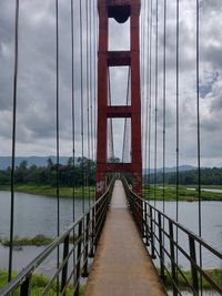 View of suspension bridge against cloudy sky