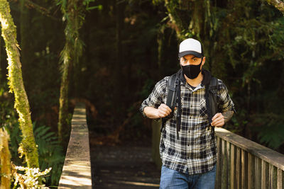 Portrait of man wearing mask standing in forest