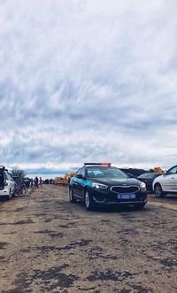 Cars parked on road against sky in city