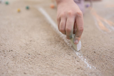 Girl draws with colorful crayons on pavement. children's drawings with chalk on wall. creative kid. 