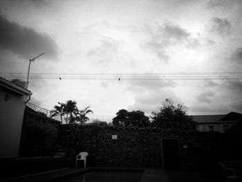 Electricity pylon against cloudy sky