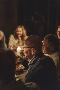 Senior man with friends enjoying at candlelight dinner party