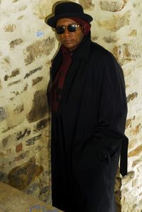 Man wearing sunglasses standing against wall